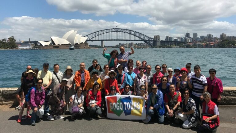 Group photo of GoGo Travelers with Sydney Opera House background during Australia, Ayers Rock, Tasmania 16-Day Panorama Tour