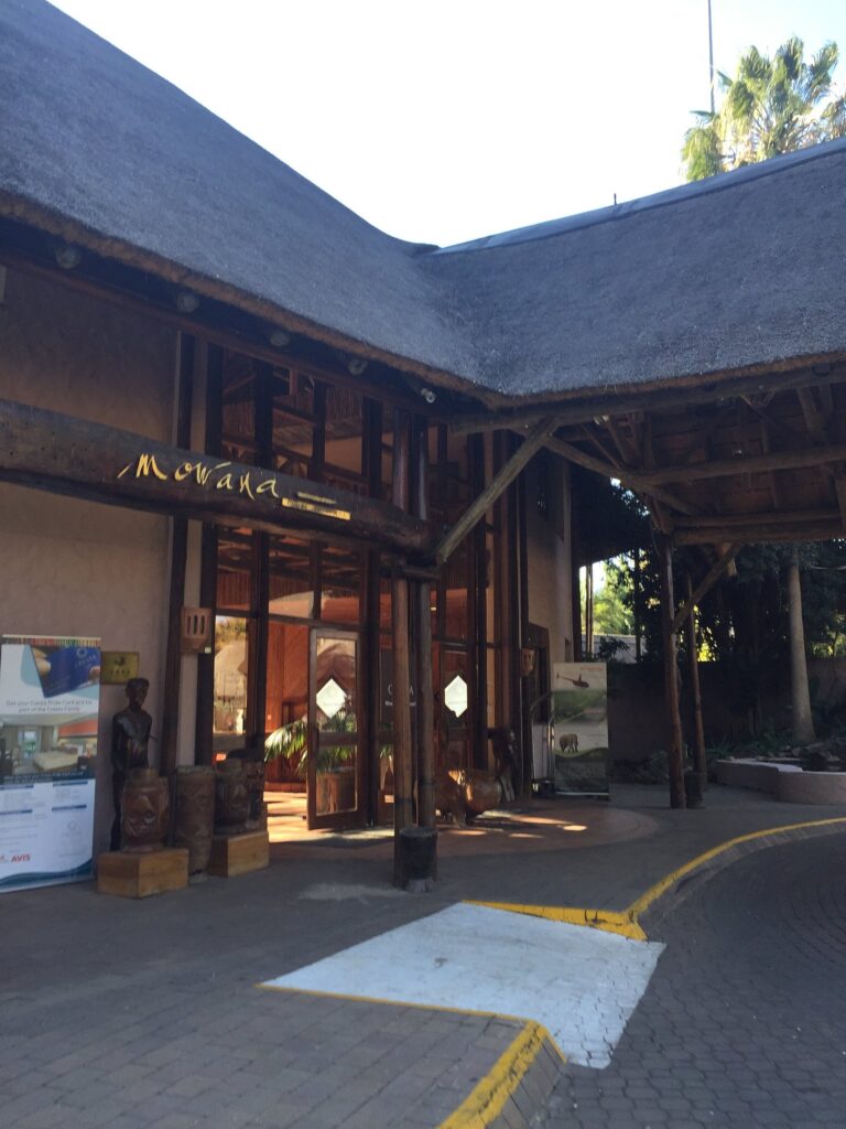 Entrance of Mowana Hotel featuring sculptures and signage.