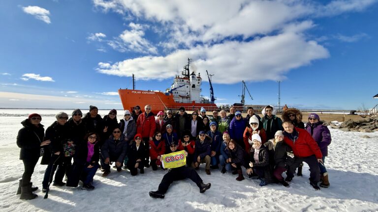 Group of GoGo Tours travelers posing in front of the Polar Explorer icebreaker on the Arctic Circle 9-Day Tour.