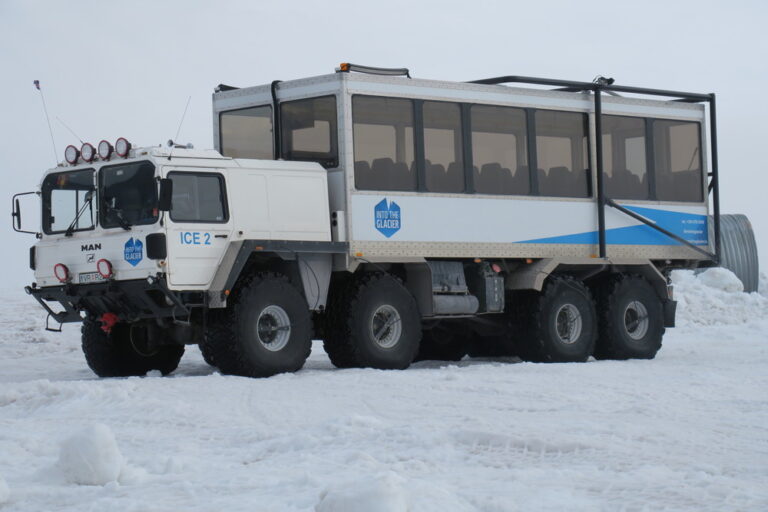 Glacier tour truck on snowy landscape in Iceland.