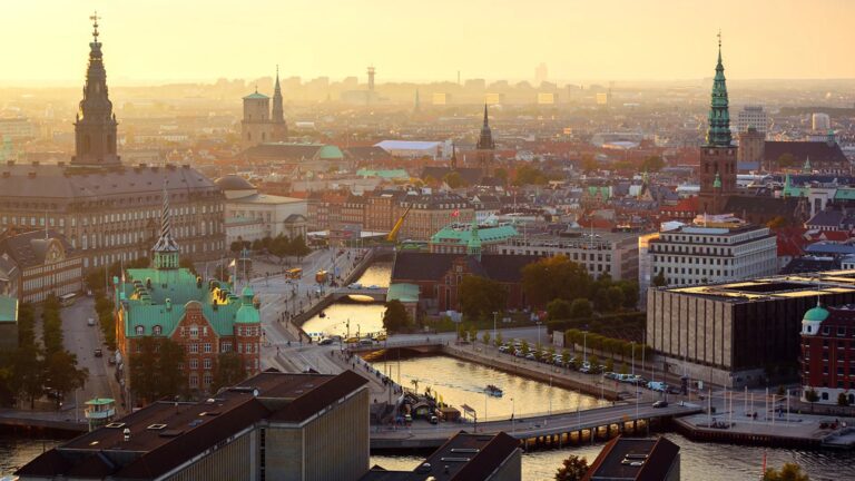 Scenic view of Copenhagen cityscape at sunset with canals and historic architecture